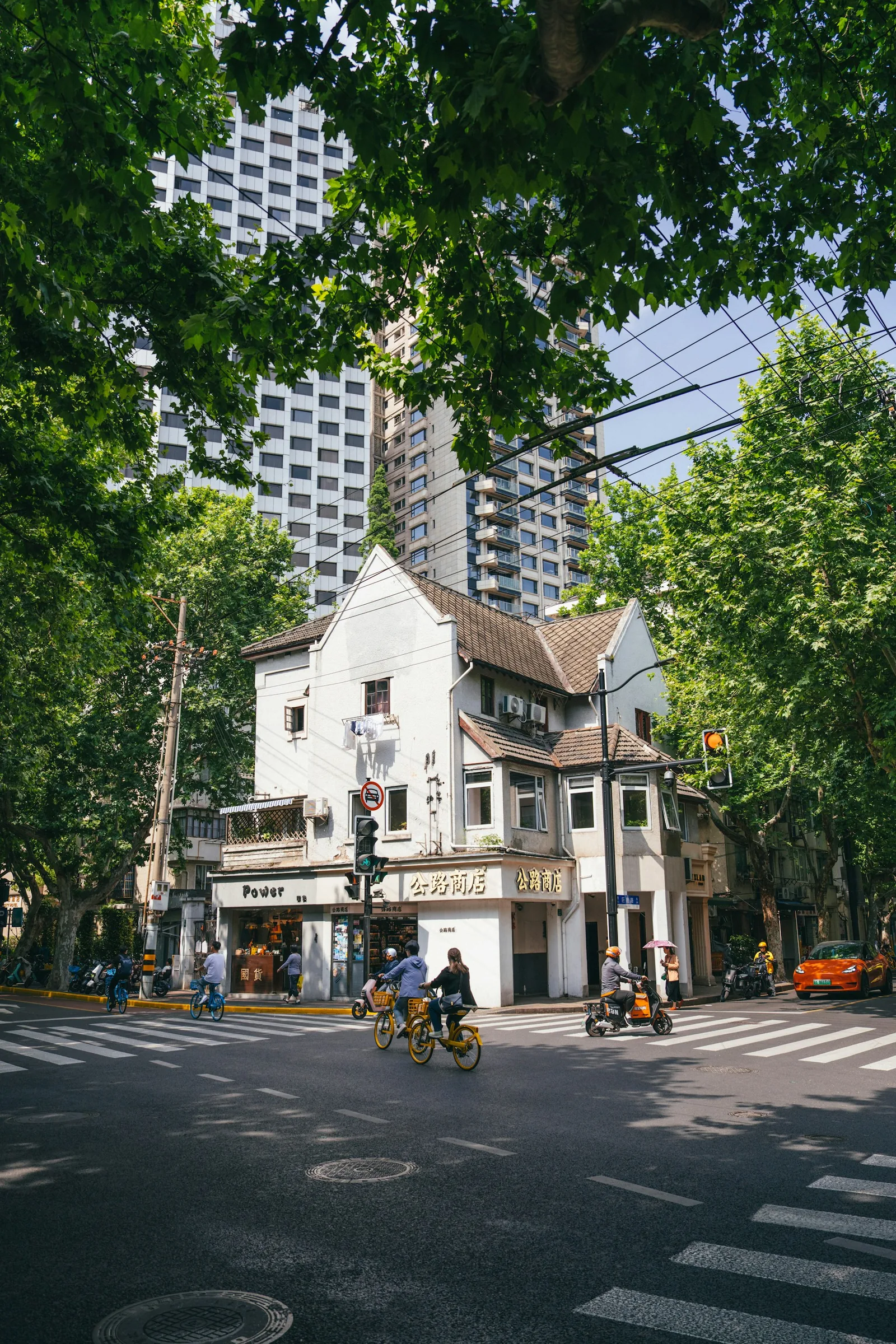 騎行者與行人經過上海梧桐街區的歷史街角