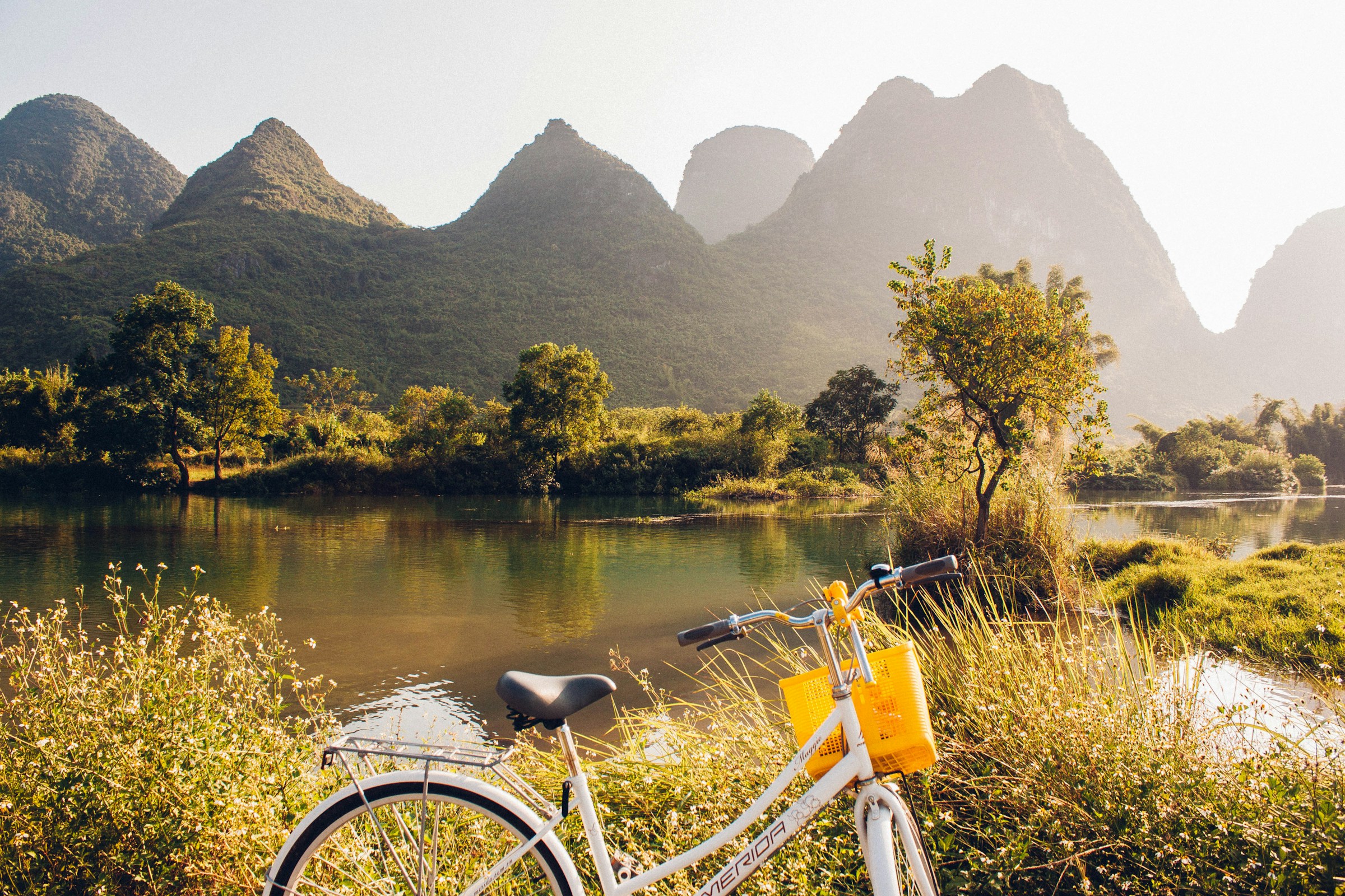 Bicycle beside a river with layered karst peaks in Yangshuo, China